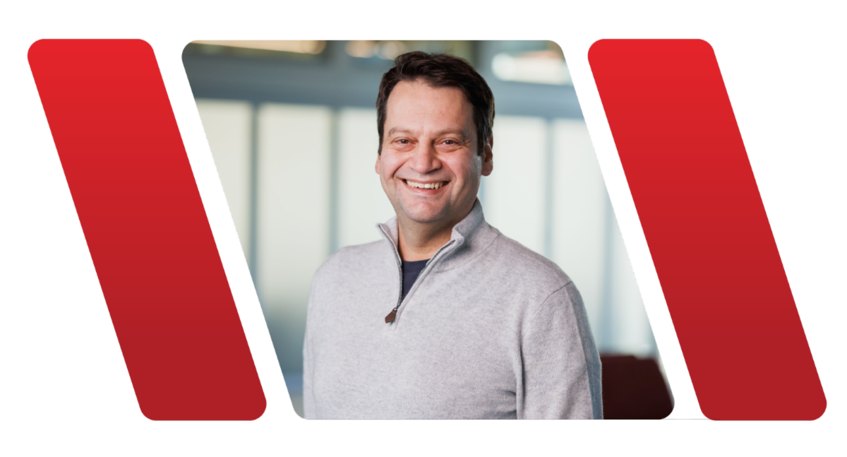 A color photo of a man smiling for a photo.