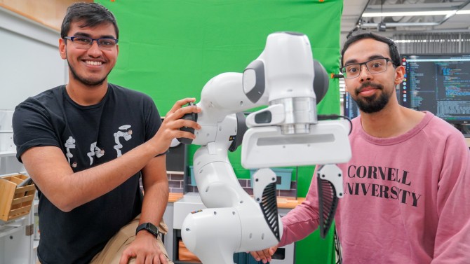 Louis DiPietro/Provided Kushal Kedia (left), a doctoral student in the field of computer science, and Prithwish Dan, M.S. ’26, are members of the development team behind RHyME, a system that allows robots to learn tasks by watching a single how-to video.