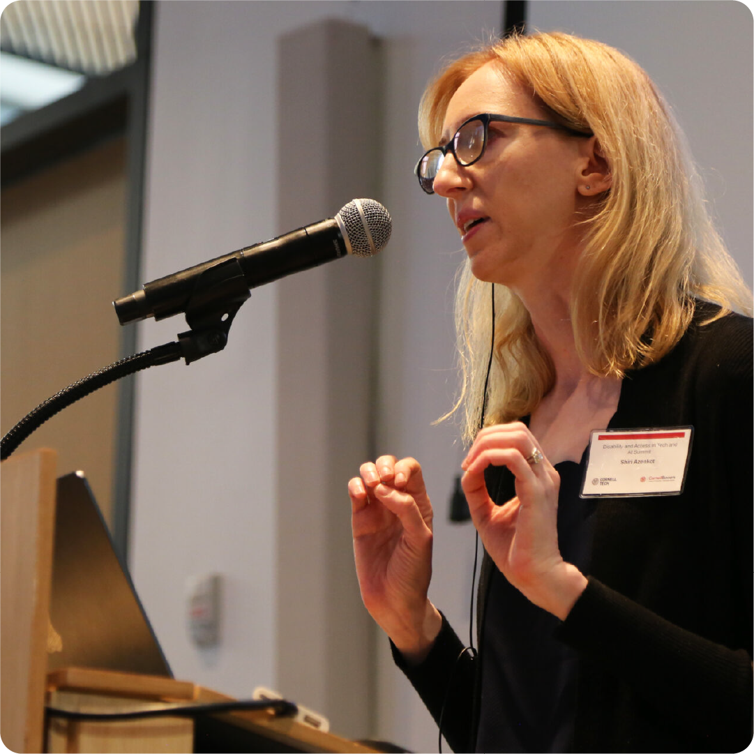 professor shiri azenkot speaking at a podium at the disability and access in tech and AI summit at Cornell Tech