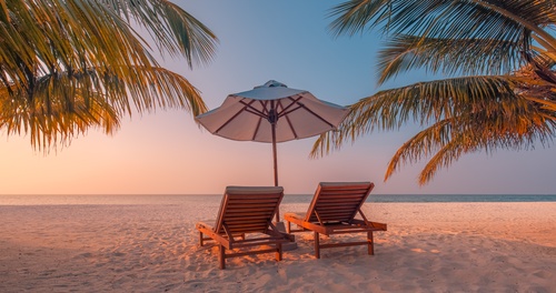 Breathtaking tropical beach resort golden hour palm trees beach chairs umbrellas serene luxury travel destination paradise vacation relaxation coastal scenery warm sunset. Summer love couple vacation