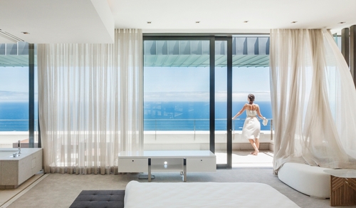 Woman on modern balcony overlooking ocean