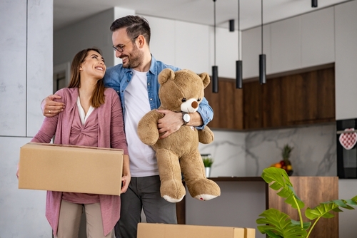 Happy young  family with cardboard boxes in new house at moving day.Concept of buying your own home and moving.