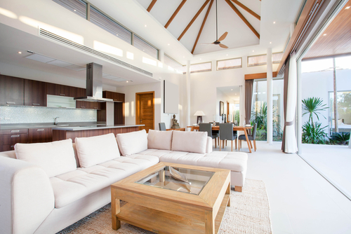 Luxury interior design in living room of pool villas. Airy and bright space with high raised ceiling_ sofa_ middle table_ dining table and open kitchen home_ house_ building _ resort 