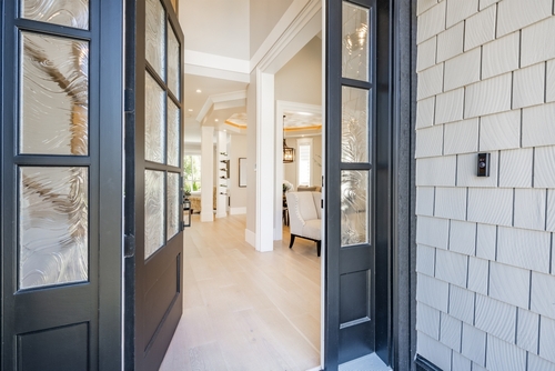 Interior foyer entry front door with hat rack coat hooks decor wood and tile flooring open door vaulted ceiling exposed brick wall welcome to a warm and comfortable family home