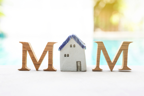 Mother s day concept_ Wooden M text with vintage style ceramic house over blurred swimming pool background_ outdoor day light