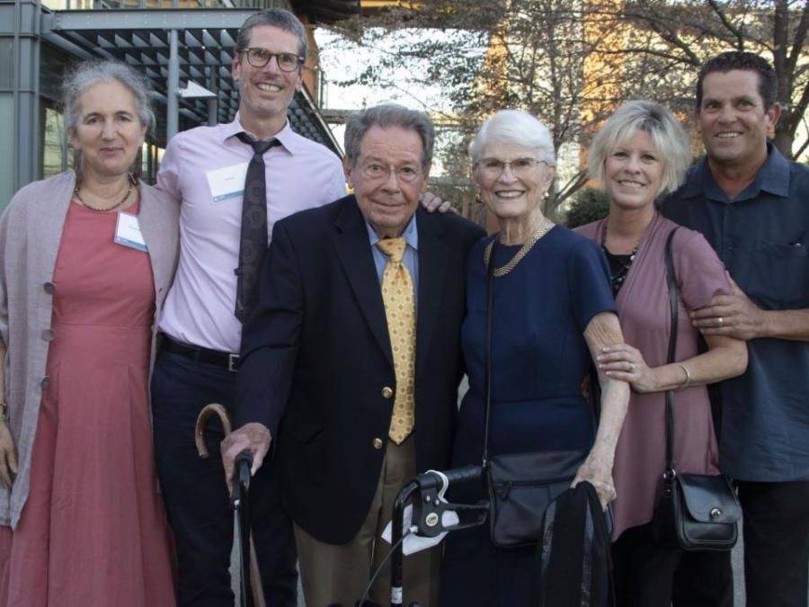 A group of people of varying ages standing outside