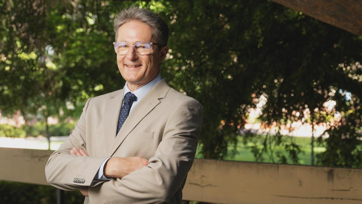 A man in a tan suit standing outside