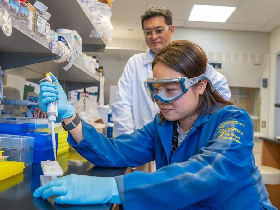 A mand and woman in blue lab coats in a laboratory setting
