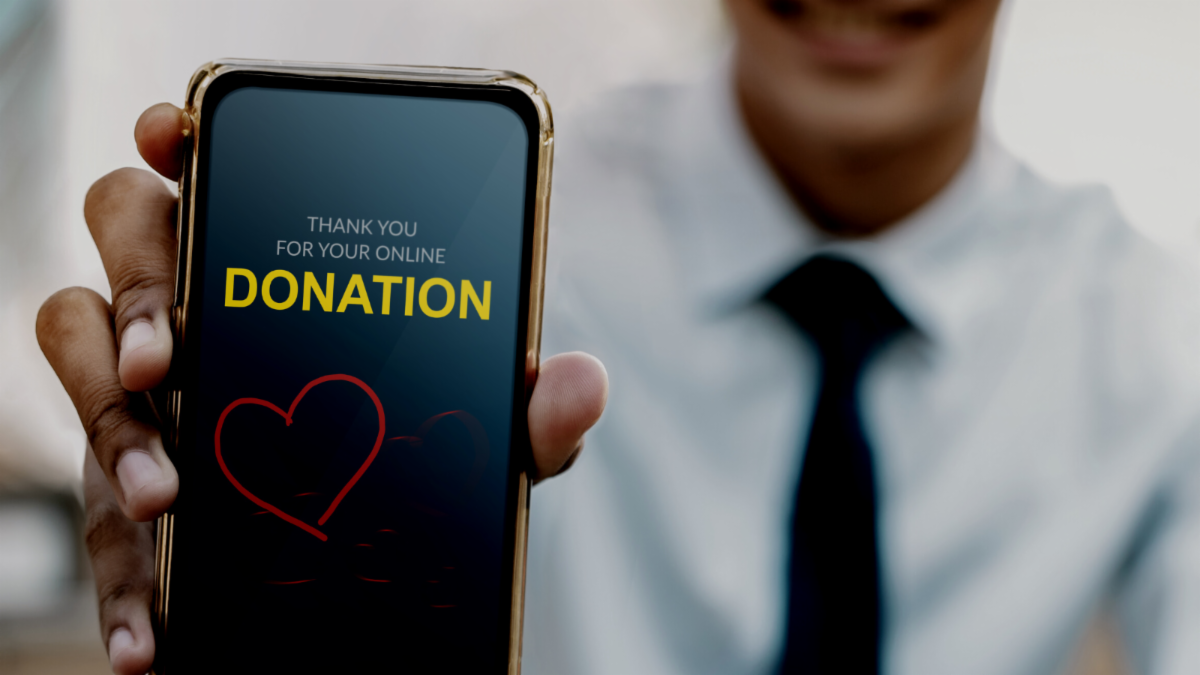 A person showing their cell phone screen that says thank you for your online donation.