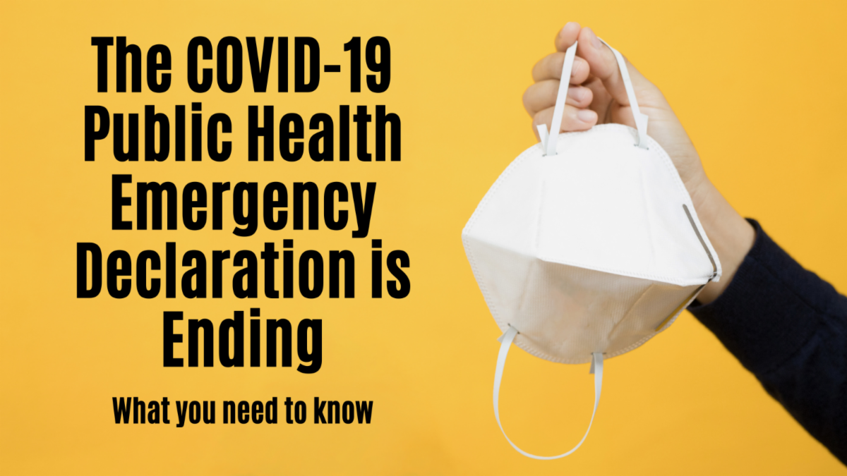 A hand holding a facemask. The COVID-19 public health emergency declaration is ending. What you need to know.