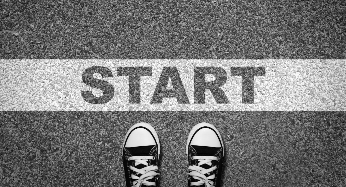 A white start line painted on the ground with two feet behind it.