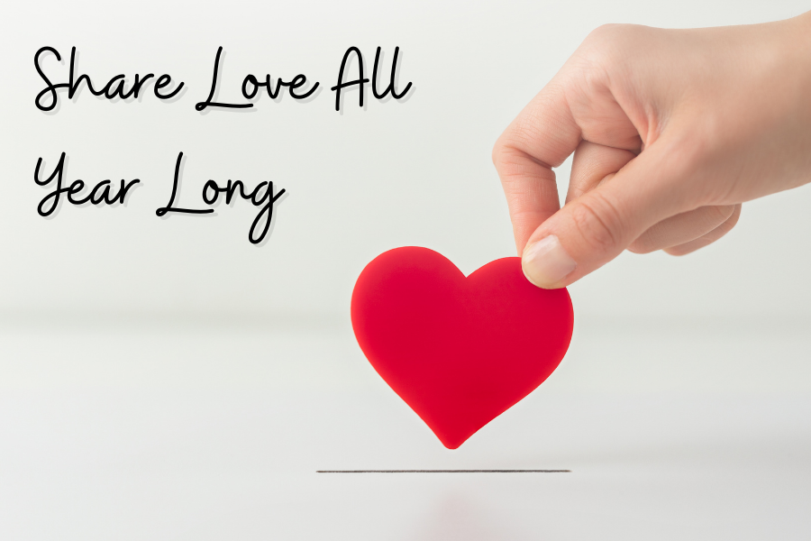 Hand holding a red heart. Text in the top left corner says Share Love All Year Long.