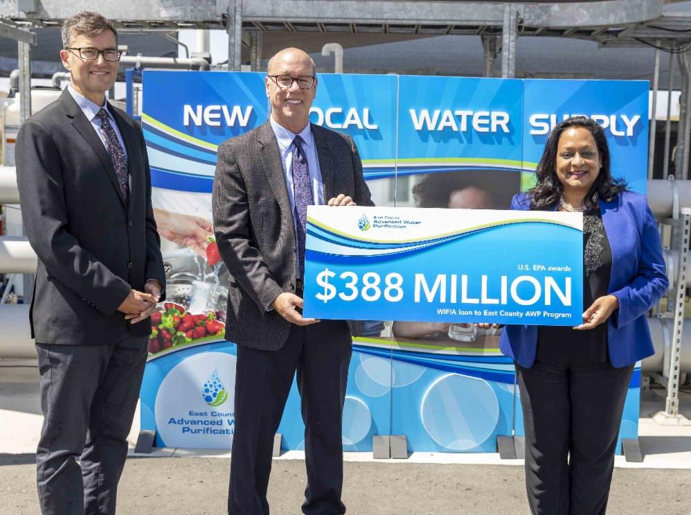 Radhika Fox  presenting $388 million loan to East County AWP representatives Steve Goble and Kyle Swanson