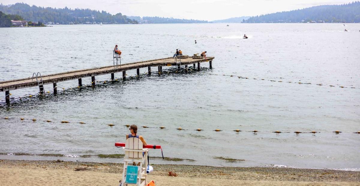 Enatai Beach Park featuring a lifeguard and visitors on the dock during the day