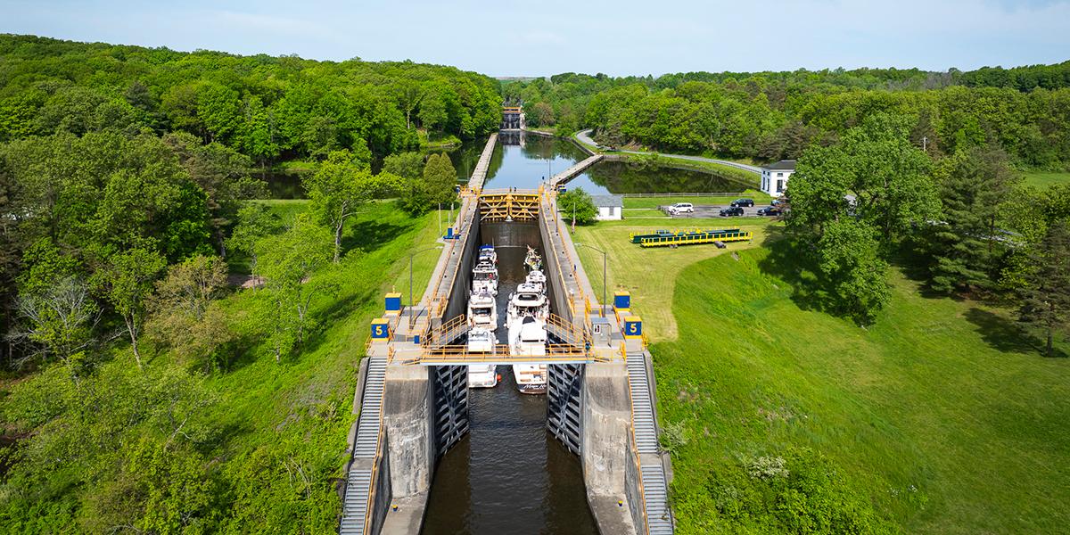 An aerial view of a lock full of boats with greenery all around