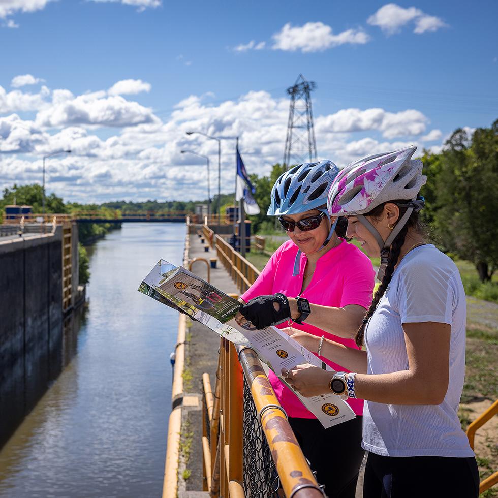 Two women look at a map while at a lock on the Erie Canal.
