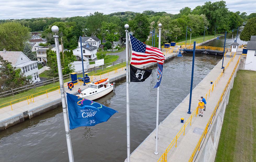 Aerial view of a lock with flags flying and a boat locking through.