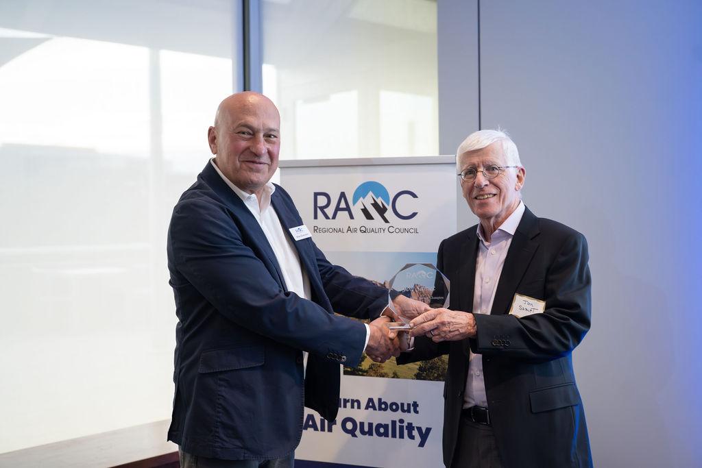 Two people shake hands as award is presented