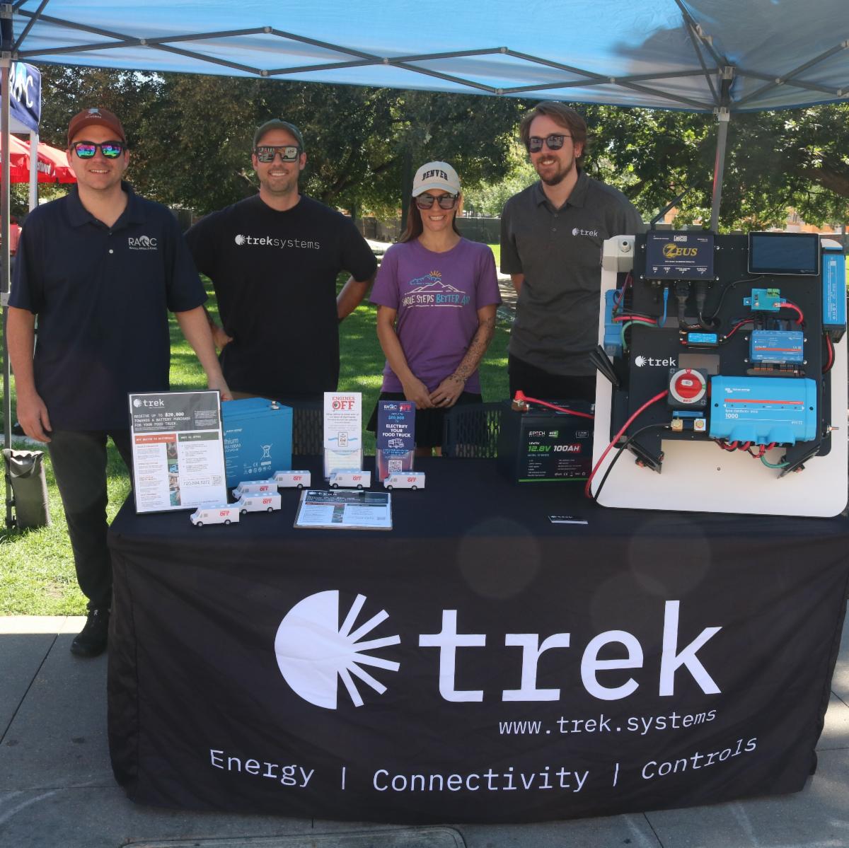 People stand at Trek Systems table