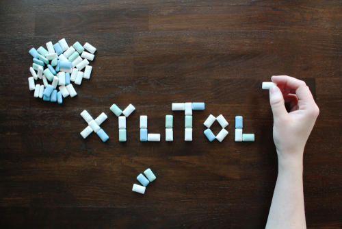 Chewing Gum with Xylitol on Brown Wooden Table. Xylitol is a sugar alcohol used as a sugar substitute. 