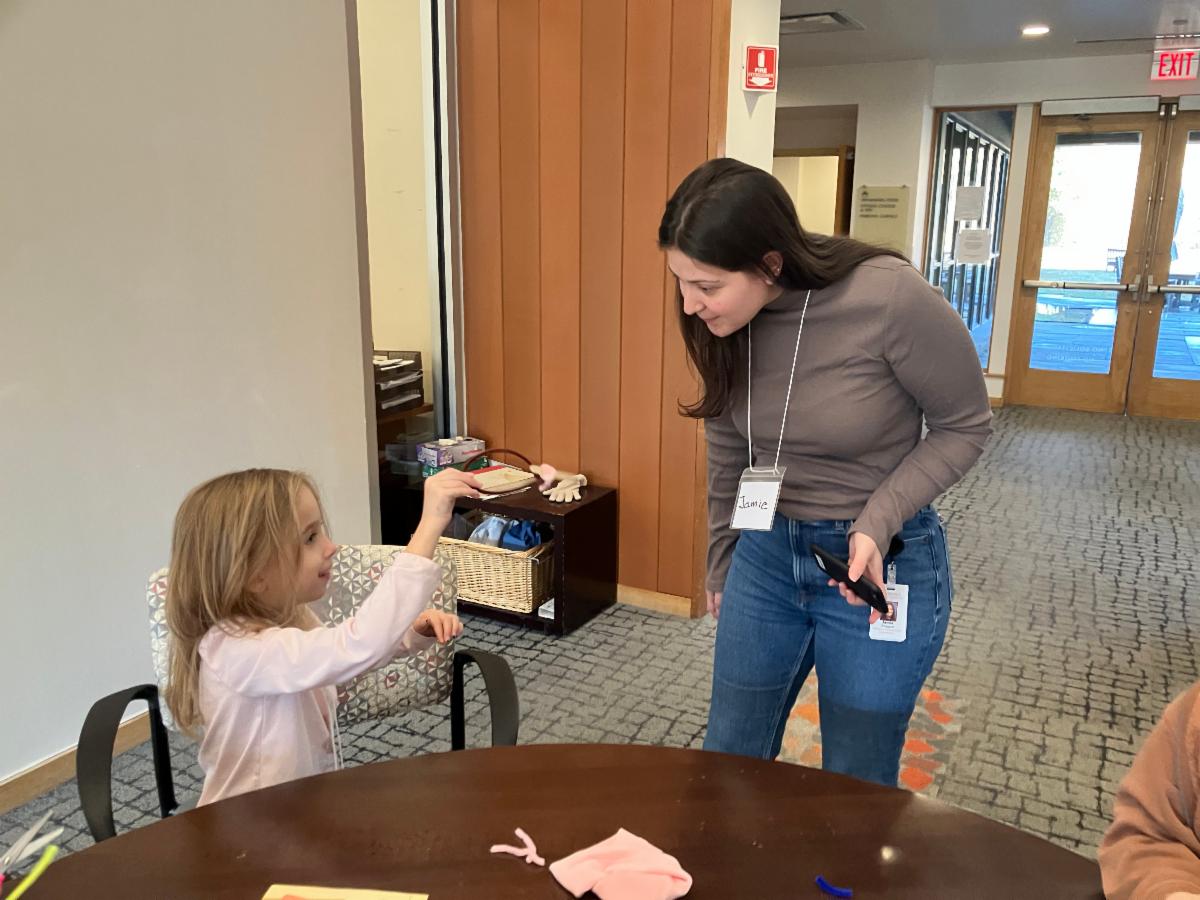 a child at one of our multigen programs shows Jamie her creation and Jamie leans down with sincere interest