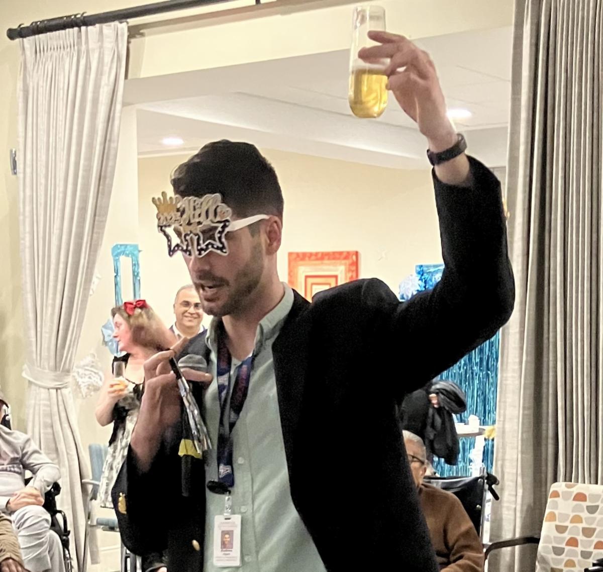 Andrew holds drink up at New Years Eve winter formal event
