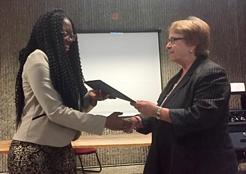 Melahicia receives a certificate from Commissioner Mikula