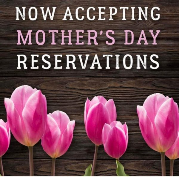 The words Now Accepting Mothers Day Reservations in white text all caps above pink tulips