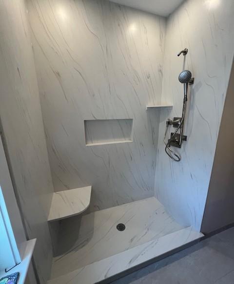Picture of white marble shower with built in shelves and seat