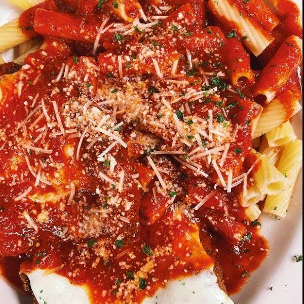 Close up image of chicken parm and pasta