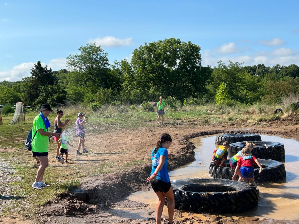 SPLAT!, a mudrun for kids, will be held July 11 at Gans Creek Recreation Area. Photo shows kids running through a mud obstacle course. 