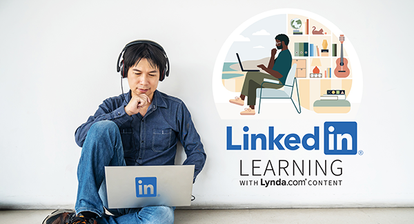 Young Asian man sitting with laptop in front of a white brick wall with LinkedIn Learning graphic on the wall