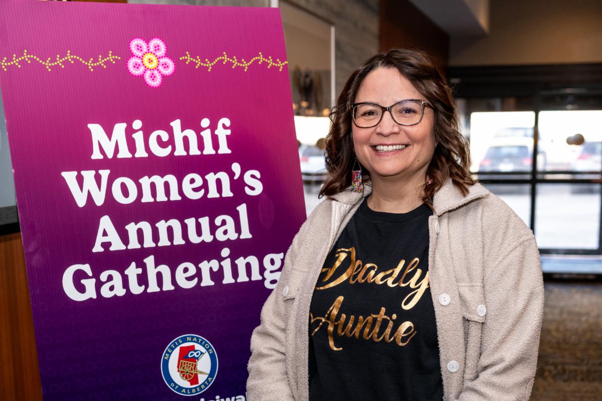 President with Michif Women's Annual Gathering Banner, click to open link