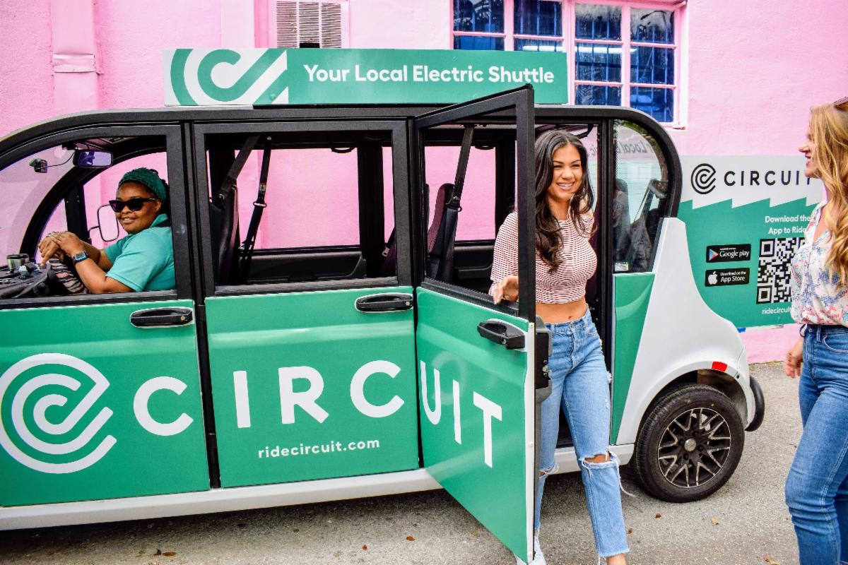 Image of a woman exiting a green circuit vehicle