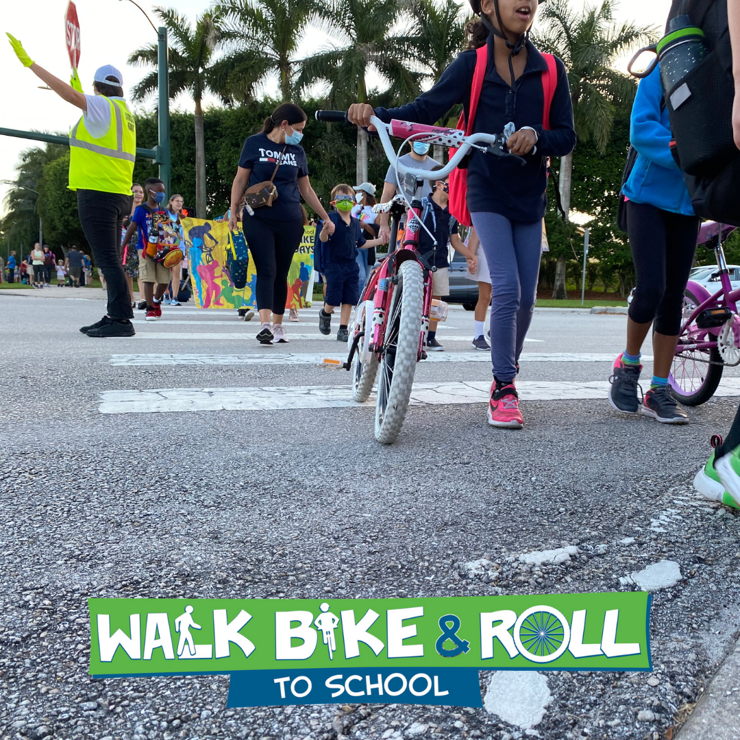 Kids crossing crosswalk with bikes with logo walk bike and roll to school