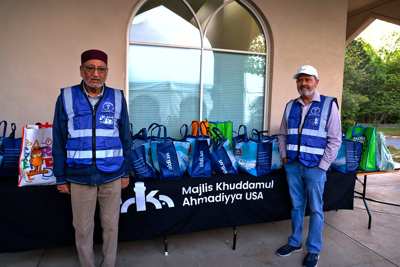 Volunteer pose with Humanity First bags stocked full of food.