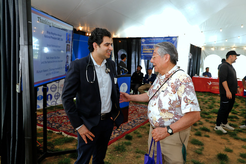 A doctor speaks with a person attending the Community Resource Fair.