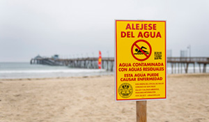 Yellow pathogen warning sign at beach.