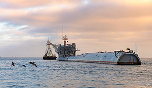 A tug tows research platform FLIP out of San Diego Harbor.