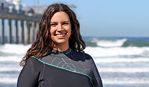 Woman in wetsuit standing by Scripps Pier.