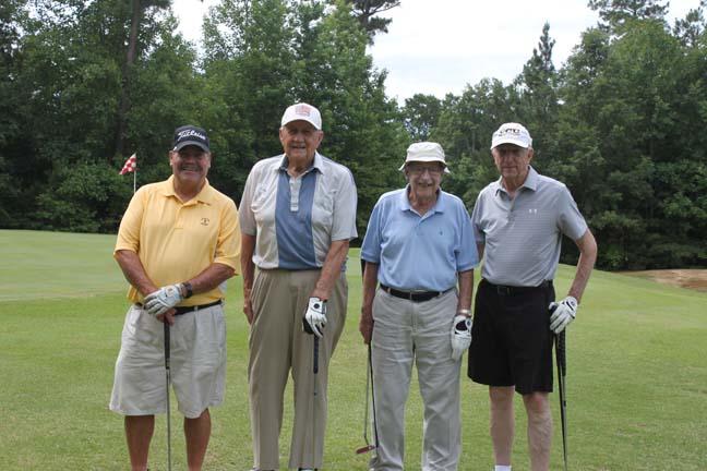 four people with clubs on golf course