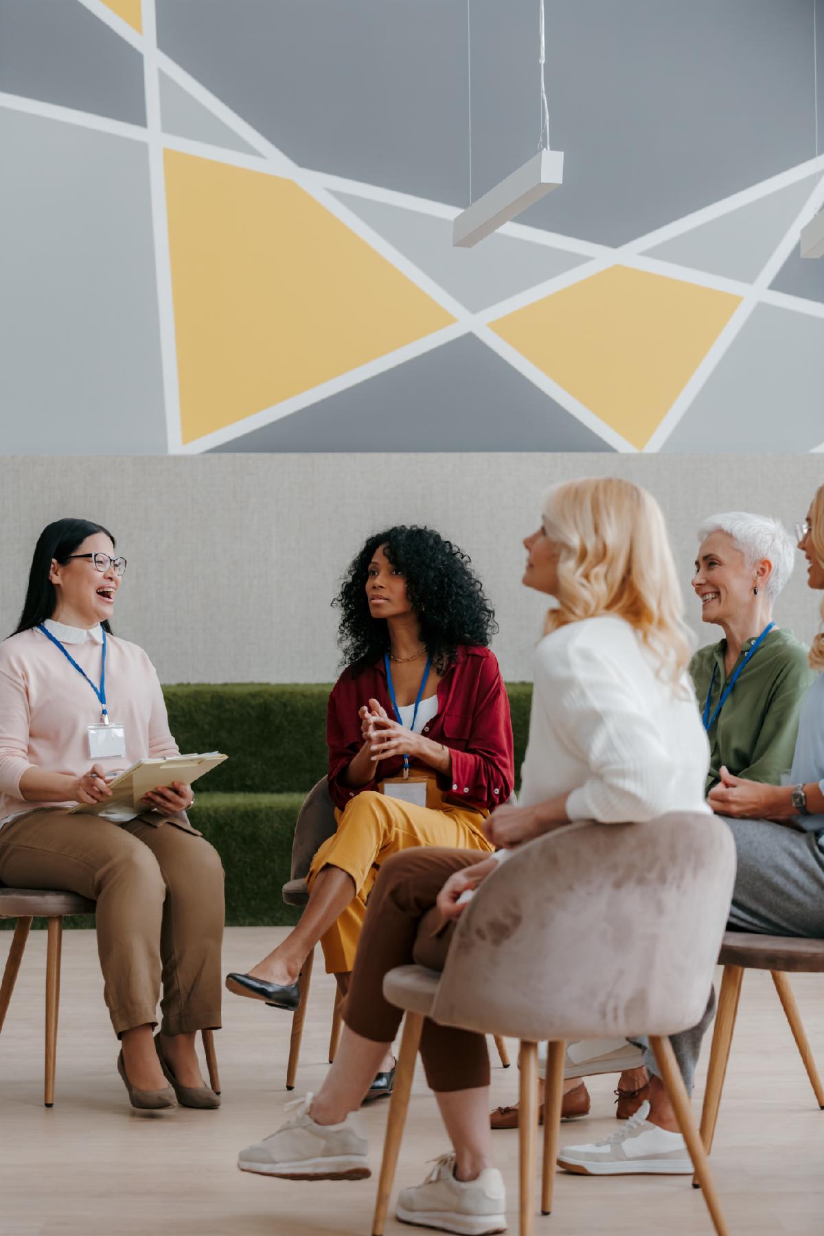 Mature women communicating and smiling while visiting group training class