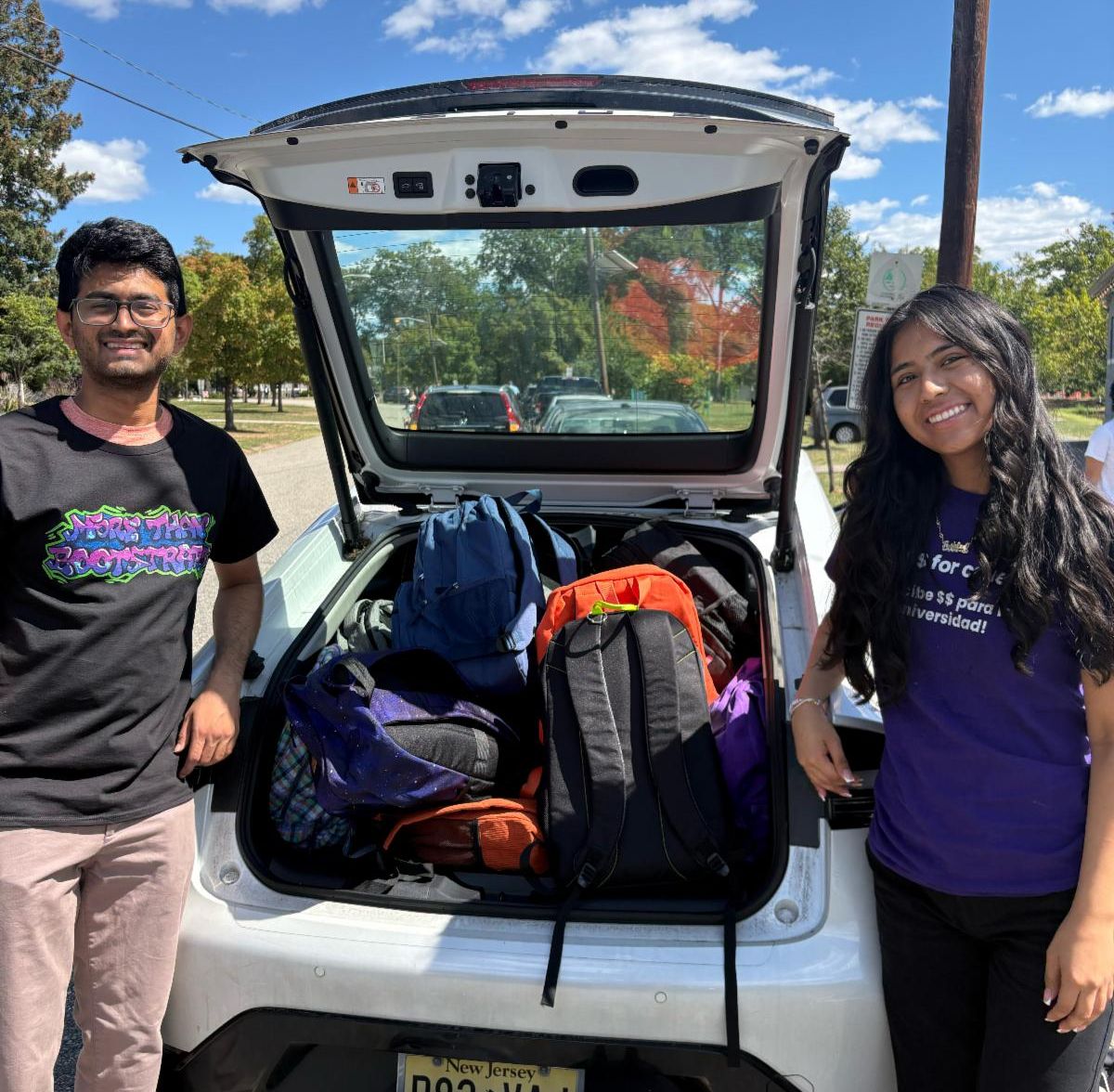 Manan and Ashley handing out backpacks to HS Fellows
