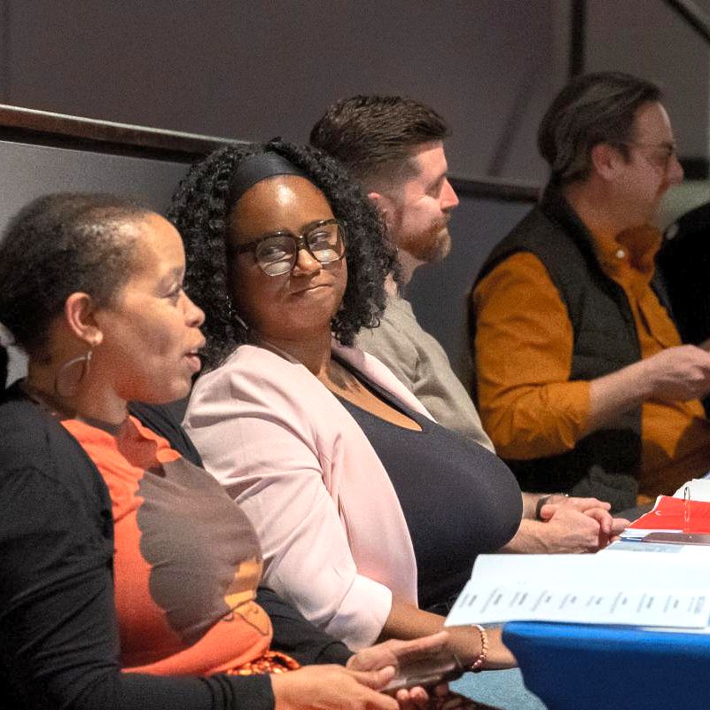 Judges seated at long table in an auditorium