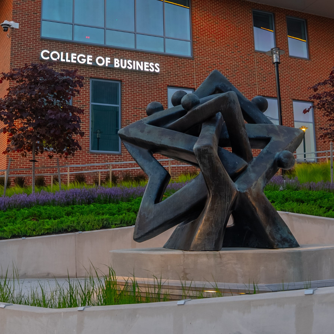 community of stars sculpture outdoors in front of coppin university college of business sign