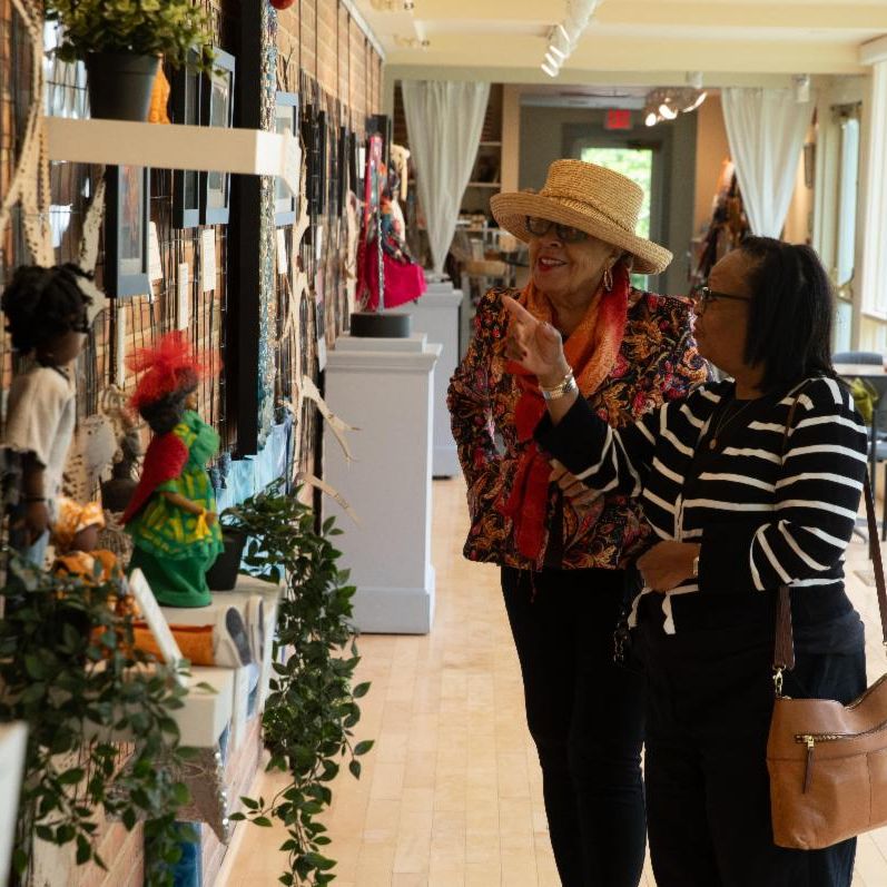 two older woman admiring art on the wall in a gallery