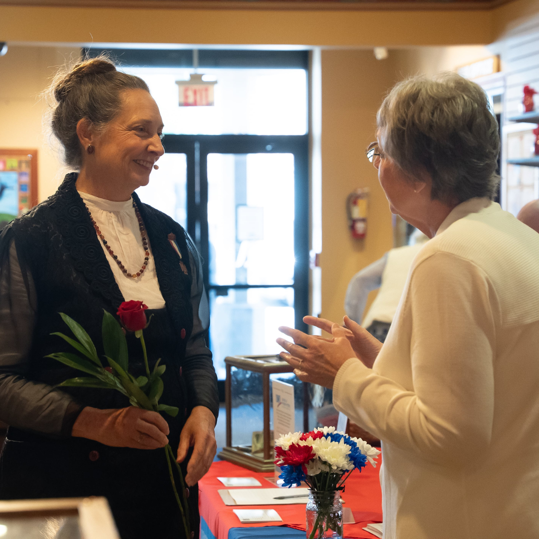 two women chatting and laughing in art gallery