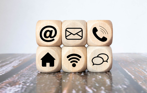 Contact Methods. Close-up of a phone_ email_ chat and post icons wooden block
