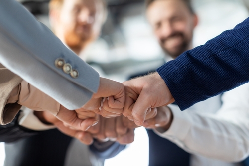 Cropped of a business teams hands clasped together in a fist bump_ showcasing their camaraderie and unity. The image captures the essence of teamwork and collaboration in a professional setting.