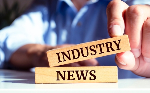 Closeup on businessman holding a wooden block with  INDUSTRY NEWS _ Business concept